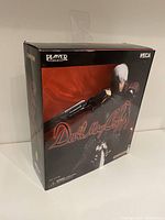 Front and angled shots of the new Devil May Cry Dante figure in its original sealed box with detailed artwork.