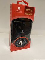 Front view of the Smart Accessories 4-port USB wall charger in packaging showing the product inside and branding.