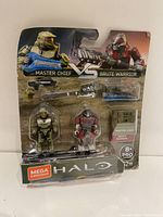 Full view of the sealed Halo Master Chief vs Brute Warrior figure set packaging presenting figures, weapons, and display stand.