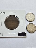 Photo showing three coins: two Canadian dimes dated 1968 with visible wear, and one 1903 Canadian One Cent coin in protective holder.