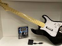 Full view of Rock Band 3 Fender guitar controller, Rock Band 3 game case, and USB wireless receiver with adapter