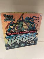 Front view of the Teenage Mutant Ninja Turtles board game box showing four turtles characters and title.