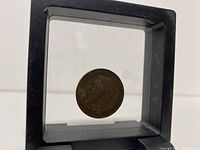 Obverse side of vintage bronzed coin showing King George V profile and inscription.