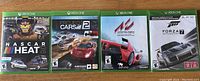 Front view of all four Xbox One game cases including NASCAR Heat 2, Project Cars 2, Assetto Corsa, and sealed Forza Motorsport 7.
