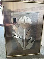 Front view of the flower mirror art depicting a stylized flower with leaves etched into the mirror surface, with room reflections visible on the mirror.