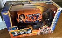 Front view of the boxed WWE Raging Racers John Cena Rumble Van with radio control visible through packaging window.
