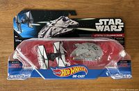 Star Wars Hot Wheels die-cast package showing the First Order TIE Fighter and Millennium Falcon models unopened in blister packaging with some peeling on the plastic case.