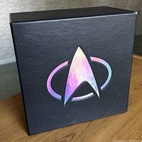 Black collector box with holographic Star Trek insignia on the front, closed.