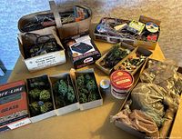 Overview photo showing assortment of wiring, scenic materials, animal figures, trees in boxes, and vintage power packs in original packaging on table