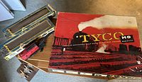 Vintage model train cars on a table with Tyco HO The General 1860 series engine box and loose engine and parts.