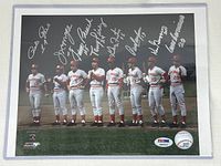 Full view of signed photograph in protective sleeve showing all eight signatures
