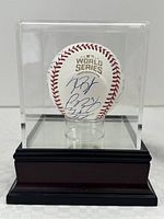 Front view of baseball in case showing gold logo and signatures