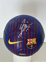 Front view of soccer ball showing Nike swoosh, FC Barcelona crest and Messi signature