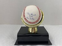 Front view of baseball on stand showing inscription "The Mick and the Judge"