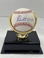 Baseball on gold-tone glove stand, front view