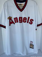 Full front view of white Angels jersey showing script logo, V-neck collar, sleeve trim and lower patches
