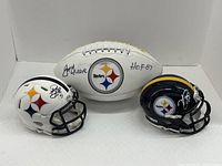 Front view showing two mini helmets flanking signed commemorative football