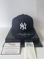 Cap displayed on stand alongside Fanatics authentication card and size/notes card