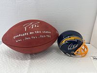 Front view of official Wilson NFL leather football and Chargers mini helmet side by side