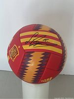 Front view showing red and yellow striped panels with black autograph overlay