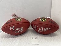 Both footballs side by side showing signatures on the panels