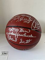 Front-facing view of basketball showing silver signatures of Larry Bird, John Havlicek, Charlie Scott