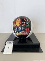 Front view of basketball on display stand showing player images