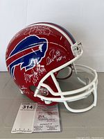 Front and side view of helmet showing multiple silver signatures and JSA card