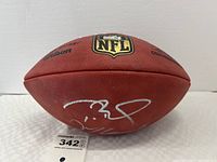 Angled view showing NFL shield logo, Wilson branding and silver signatures on pebbled leather surface