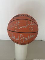 Full view of Spalding NBA Official All-Surface basketball on white pedestal showing both signatures