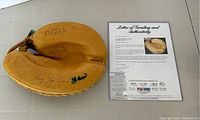 Full view of tan Reach catcher's mitt with autograph and COA on right
