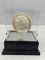 Baseball in acrylic display case with black wooden base, showing front view of autographed surface and 1992 World Series logo.