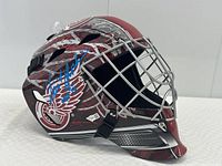 Right side view showing red and silver graphics with Detroit Red Wings winged wheel logo and blue autograph