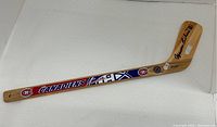 Full-length view of wooden mini stick showing Canadiens graphics and signature on blade.