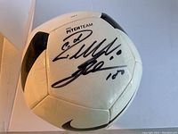 Front view of Nike Pitch Team soccer ball showing black and white panels and signatures