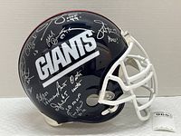 Right side view of navy helmet with white facemask showing GIANTS decal and multiple silver signatures.