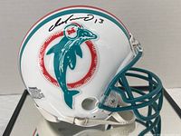 Side view of white mini helmet with teal facemask, Dolphins logo, signed "Dan Marino 13" on side