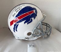 Front-left angle of signed white Buffalo Bills helmet with gray facemask and Fanatics certification sticker on base.