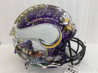 Full right-side view of purple mini helmet showing Randy Moss figure, team logo and autograph on top