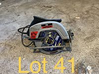 Left side view of Craftsman circular saw on floor showing blade, handle, power cord and labeling.