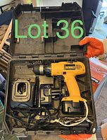 Open black hard plastic case with yellow DeWalt cordless drill, battery, charger, and additional battery inside