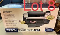 Photo of Epson Stylus Photo R300 printer in sealed box showing front packaging and key features.