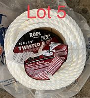 White twisted polypropylene rope coiled in a round bundle with visible label showing product information and specifications.