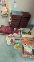 Overview of stacked Readers Digest books with brown covers and assorted other books including Bible editions and novels by Cathrine Marshall