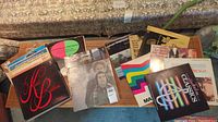 Photo showing multiple vinyl records in sleeves with visible album covers and titles