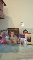 Full lot of five Royal Family themed books and commemorative mug displayed together.
