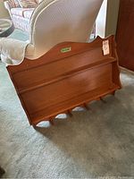 Wooden plate display shelf showing angled view of grooves and hooks