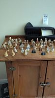 Overview of approximately 42 Wade figures arranged on wooden surface with black carrying case behind them, showing condition including some damage.