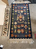 Full view of Canadian Centennial rug with coat of arms and provincial shields, and beside it the crochet hanging bird artwork.