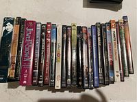 Front view of DVD cases in a row showing titles including The Diary of Anne Frank, Spider-Man 3, Star Wars episodes, Peanuts collection, and others.